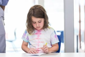 Female student working on Math problem at a desk